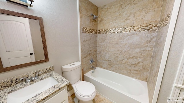 bathroom with toilet, shower / bath combination, a textured wall, and vanity