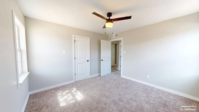 unfurnished bedroom with carpet, a ceiling fan, and baseboards