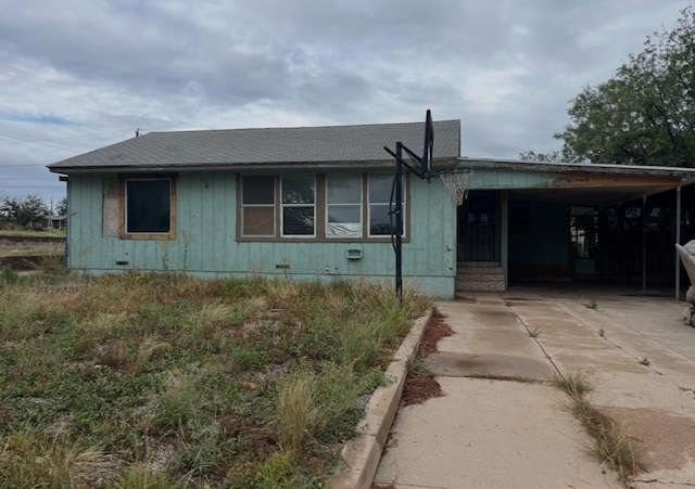 1104 S Monticello St, Big Spring, TX 79720 - view of front facade featuring a shingled roof, concrete driveway, an attached carport, and board and batten siding