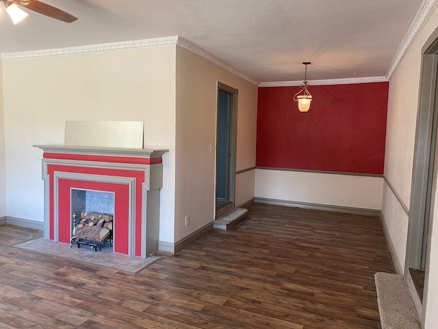 unfurnished dining area with a textured ceiling, dark hardwood / wood-style floors, ceiling fan, and ornamental molding