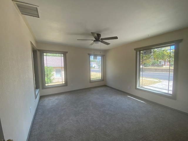 carpeted spare room featuring ceiling fan