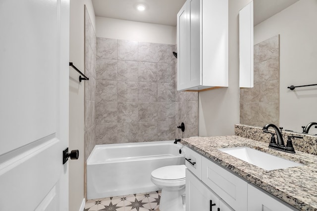 full bathroom featuring tiled shower / bath, vanity, and toilet