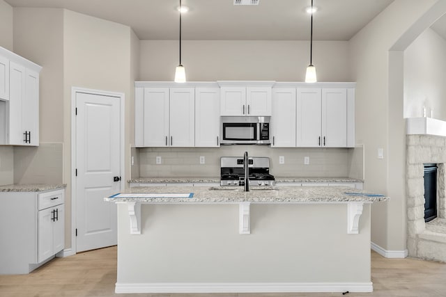 kitchen with pendant lighting, stainless steel appliances, and white cabinets