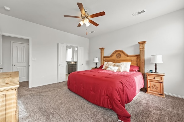 carpeted bedroom featuring ceiling fan, visible vents, baseboards, and connected bathroom