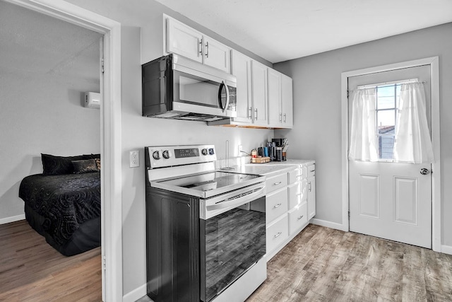 kitchen featuring stainless steel appliances, light hardwood / wood-style floors, and white cabinets