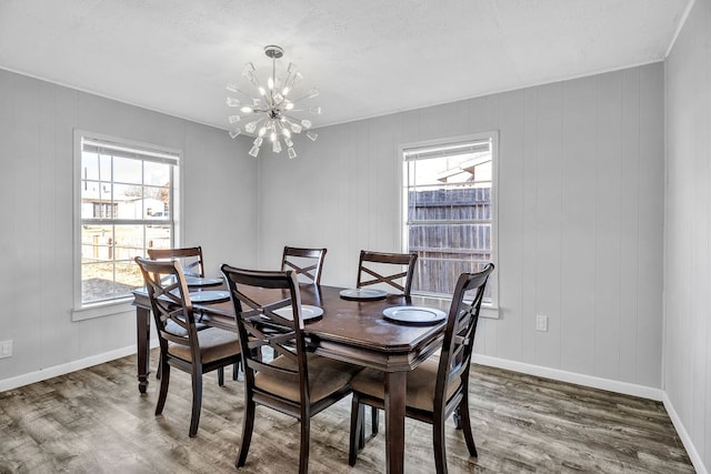 dining area with wood-type flooring and a chandelier