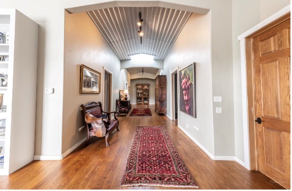 corridor with wood-type flooring and vaulted ceiling