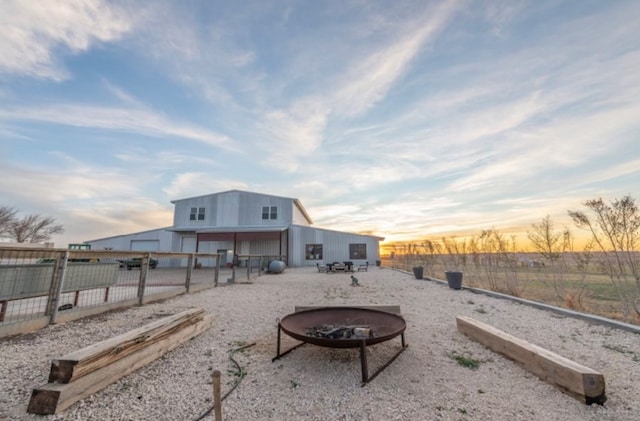 back house at dusk with an outdoor fire pit