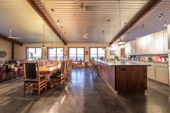 dining room featuring beam ceiling, wood ceiling, a wealth of natural light, and ceiling fan