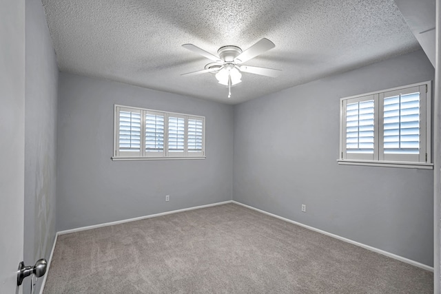 carpeted empty room with a textured ceiling, baseboards, and ceiling fan