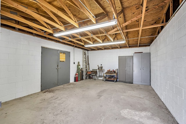 basement with concrete block wall and a garage