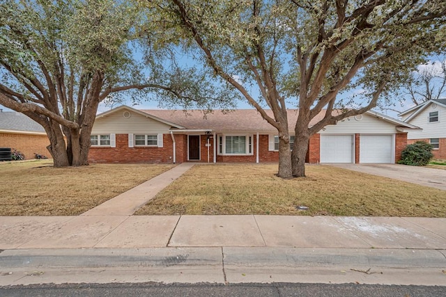 ranch-style house with driveway, a front yard, a garage, brick siding, and central AC unit