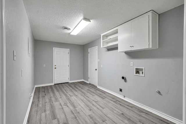 laundry room with electric dryer hookup, visible vents, washer hookup, light wood-style flooring, and cabinet space