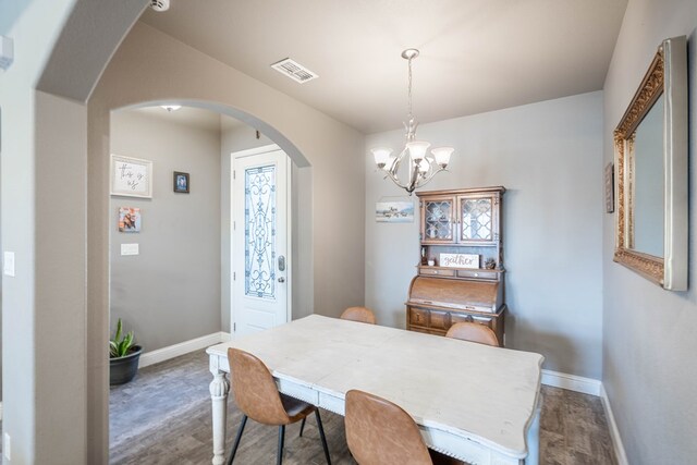 6108 Copper Sky Ct, Midland, TX 79705 - dining area with arched walkways, a chandelier, baseboards, and dark wood-type flooring