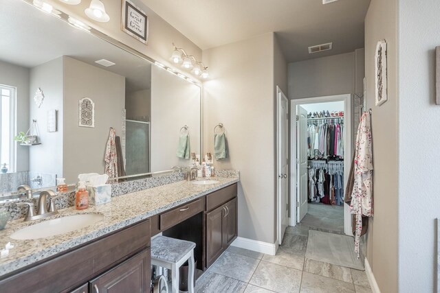 6108 Copper Sky Ct, Midland, TX 79705 - bathroom with double vanity, baseboards, an enclosed shower, a spacious closet, and tile patterned flooring