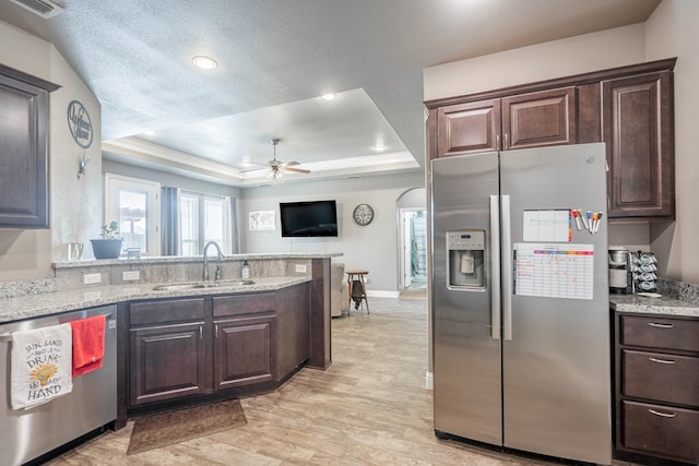 6108 Copper Sky Ct, Midland, TX 79705 - kitchen featuring appliances with stainless steel finishes, a sink, a raised ceiling, ceiling fan, and dark brown cabinetry