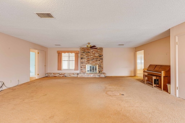 unfurnished living room featuring a fireplace, light carpet, and a textured ceiling