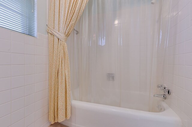 bathroom with shower / bath combo with shower curtain