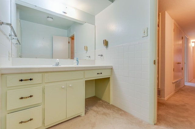 bathroom featuring vanity and tile walls