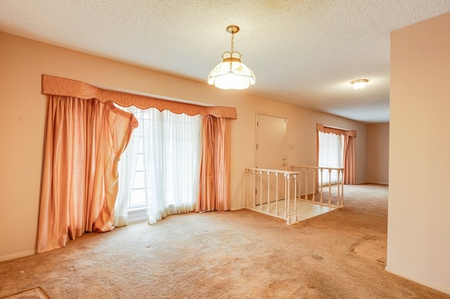 carpeted spare room with a textured ceiling