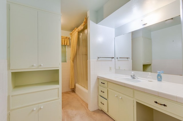 bathroom with vanity, tile walls, and shower / bath combo with shower curtain