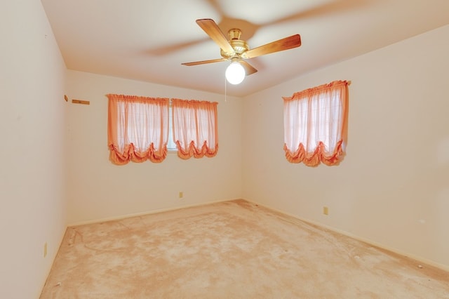 carpeted spare room with ceiling fan