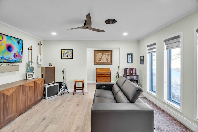 living area with ornamental molding, a ceiling fan, recessed lighting, light wood finished floors, and baseboards