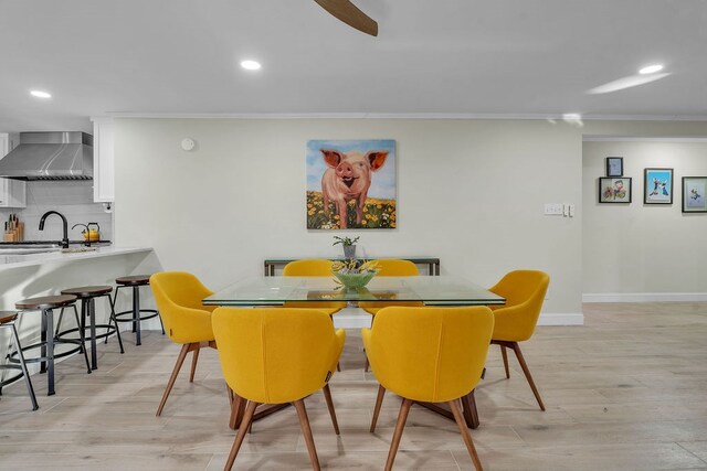 dining room featuring light wood finished floors, recessed lighting, crown molding, and baseboards