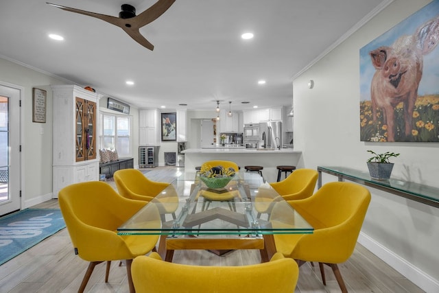 dining room with crown molding, recessed lighting, light wood-type flooring, and baseboards