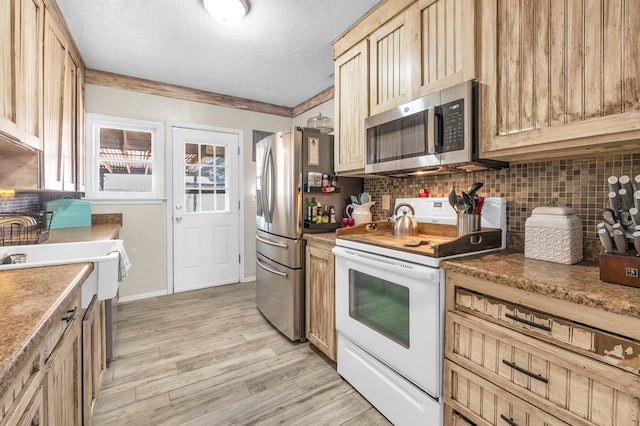 1400 W Tennessee Ave, Midland, TX 79701 - kitchen featuring stainless steel appliances, tasteful backsplash, light wood-style floors, a textured ceiling, and light brown cabinetry