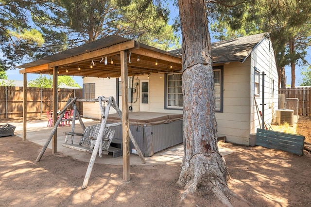 1400 W Tennessee Ave, Midland, TX 79701 - back of property with a hot tub, a fenced backyard, cooling unit, and a patio area