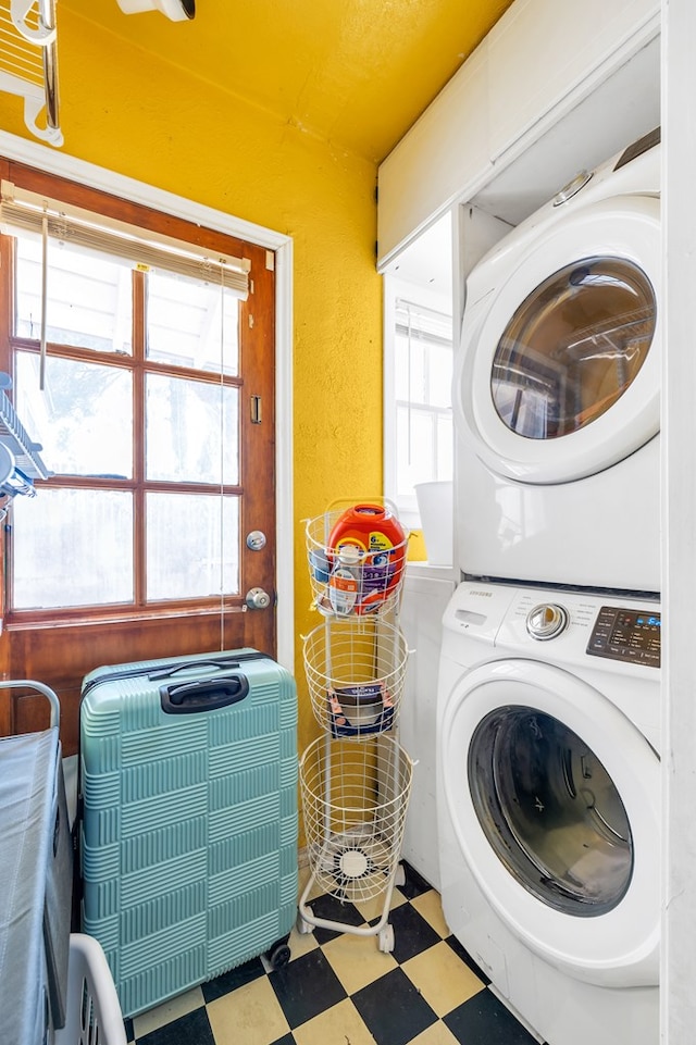 1400 W Tennessee Ave, Midland, TX 79701 - laundry area with stacked washer / dryer, tile patterned floors, healthy amount of natural light, and a textured wall