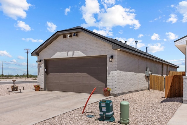 1201 Bajada St, Midland, TX 79705 - view of side of property featuring an attached garage, driveway, and brick siding