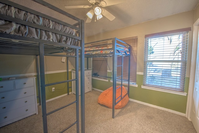 bedroom with ceiling fan, carpet flooring, and a textured ceiling