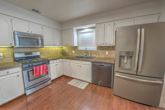 kitchen featuring stainless steel appliances, sink, and white cabinets