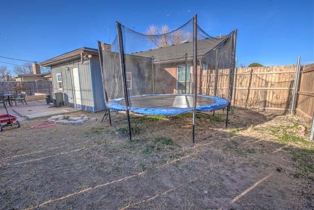 view of yard featuring a patio and a trampoline