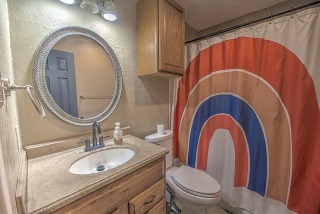 bathroom featuring vanity, toilet, and a textured ceiling