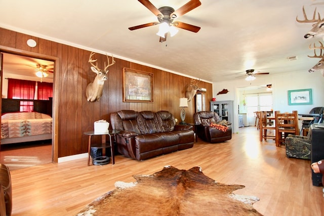7501 N County Rd 29, Big Spring, TX 79720 - living room featuring ceiling fan, wood finished floors, wood walls, and ornamental molding