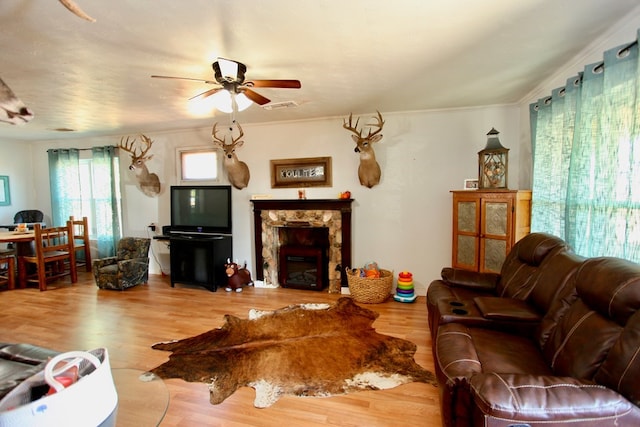 7501 N County Rd 29, Big Spring, TX 79720 - living room with a ceiling fan, wood finished floors, crown molding, and a stone fireplace