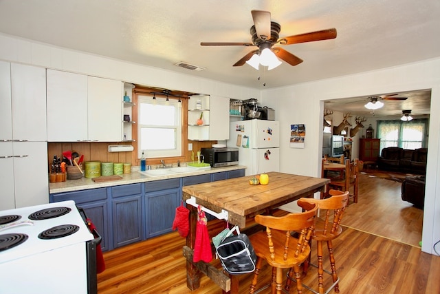 7501 N County Rd 29, Big Spring, TX 79720 - kitchen with blue cabinetry, white appliances, ceiling fan, and open shelves