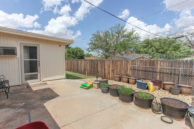 view of patio featuring a wall mounted AC and a fenced backyard
