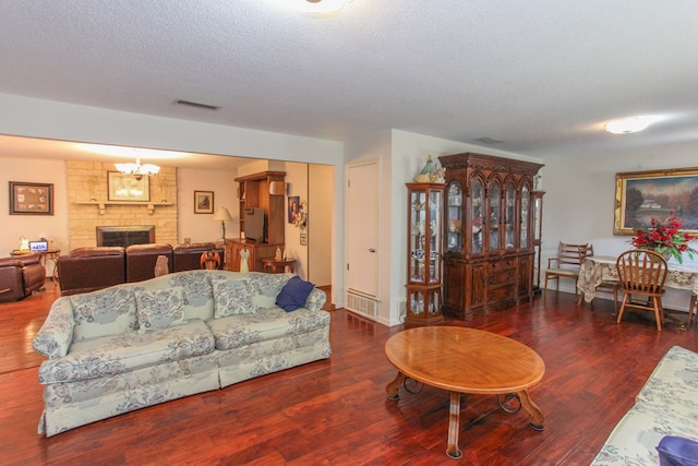 living area featuring a large fireplace, visible vents, and wood finished floors