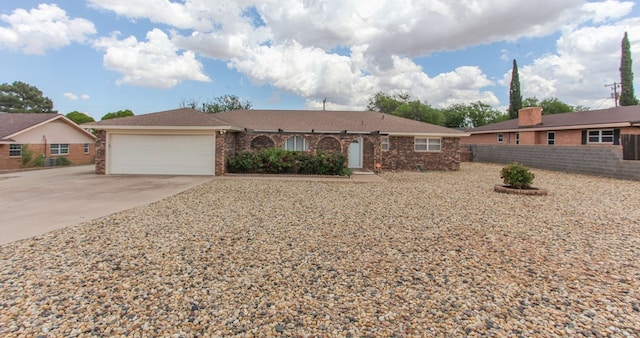 ranch-style house with concrete driveway, an attached garage, and fence