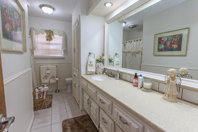 bathroom featuring vanity, toilet, and tile patterned flooring