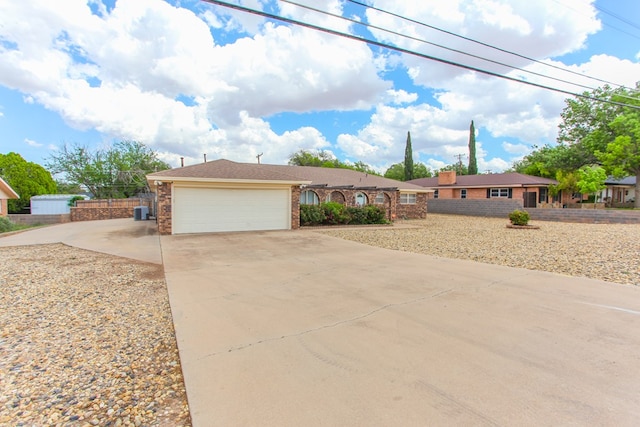 ranch-style house with concrete driveway, fence, and a garage
