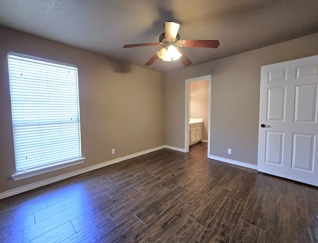 unfurnished bedroom with ceiling fan, dark hardwood / wood-style flooring, and connected bathroom