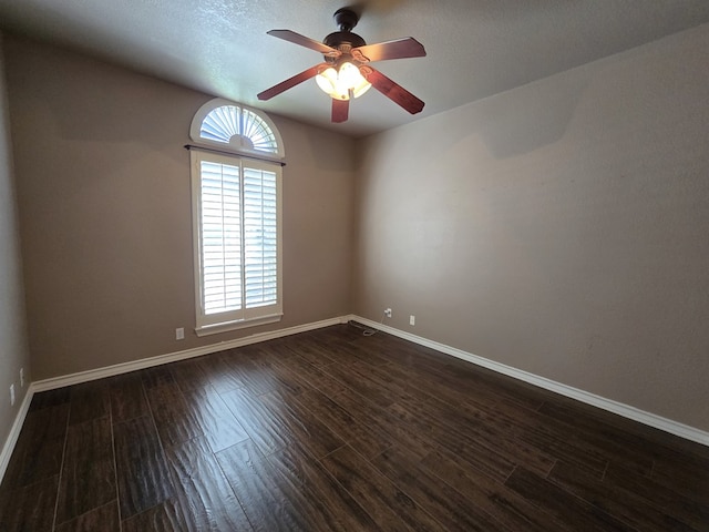 unfurnished room featuring dark wood-type flooring and ceiling fan