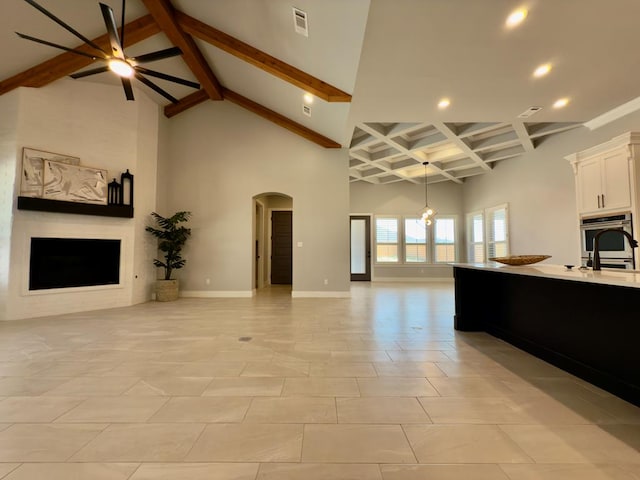 5516 E County Rd 93, Midland, TX 79706 - living area with arched walkways, ceiling fan, beam ceiling, recessed lighting, and a high ceiling