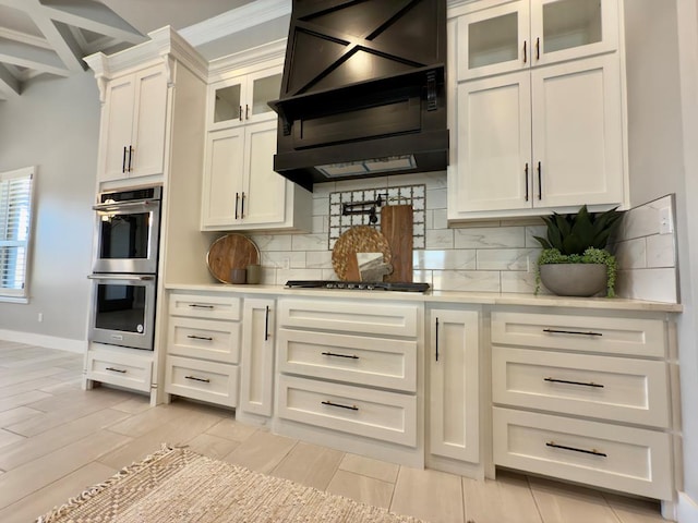 5516 E County Rd 93, Midland, TX 79706 - kitchen with appliances with stainless steel finishes, wall chimney exhaust hood, decorative backsplash, light countertops, and white cabinetry