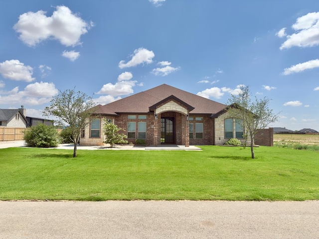 5516 E County Rd 93, Midland, TX 79706 - view of front of home featuring a front yard, stone siding, and brick siding